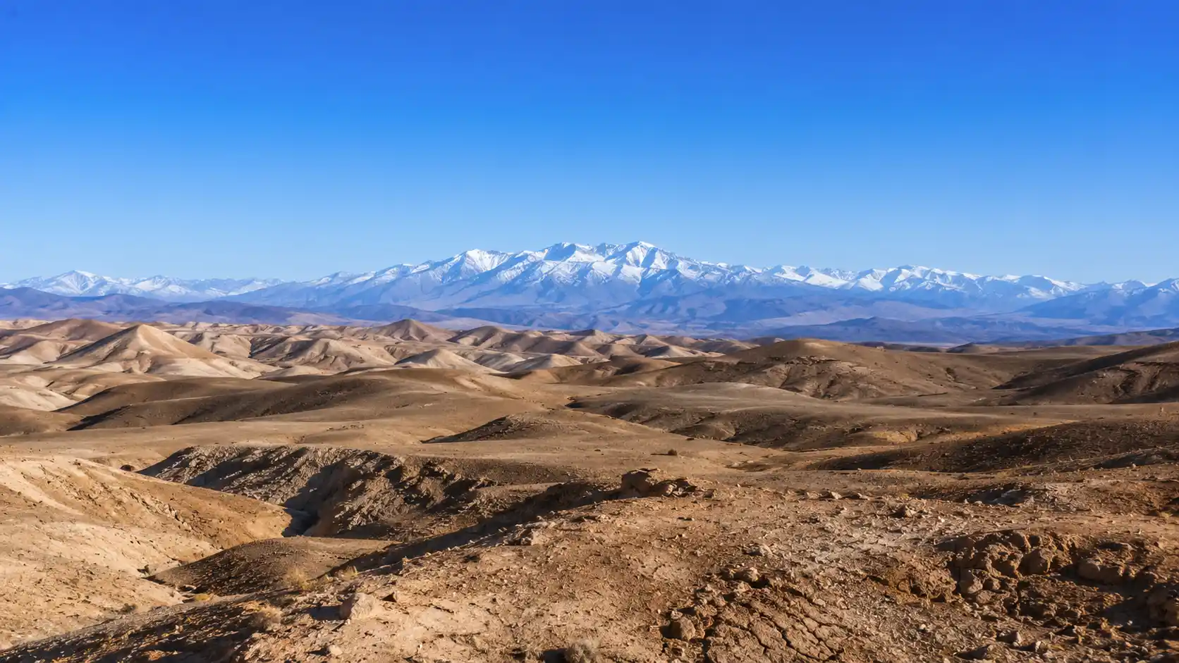 Panoramic view of Agafay Desert with rocky terrain and distant Atlas Mountains